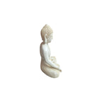 Side view of white resin seated Varada Mudra Buddha figure