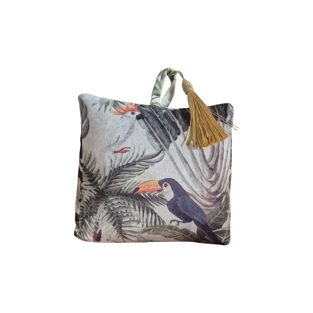 Jungle Velvet Doorstop White by LeForge — front view showing tropical cockatoo and toucan print on soft white velvet with gold tassel handle