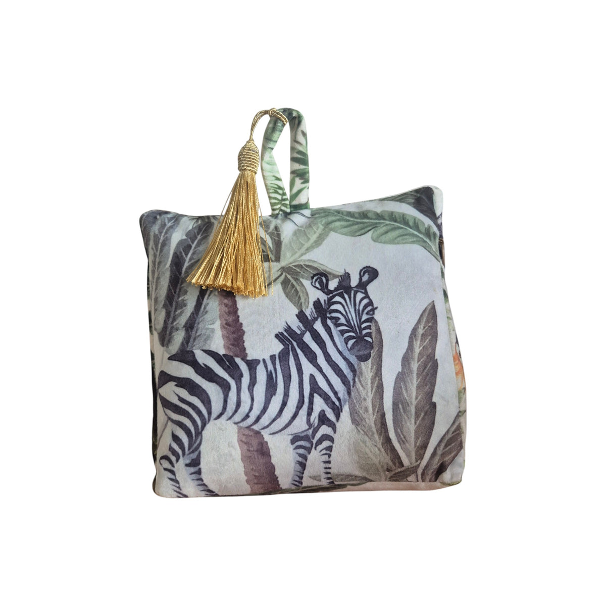 Jungle Velvet Doorstop White by LeForge — front view showing zebra-print side of doorstop with tropical palm and leaf jungle print and gold tassel