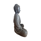 Side view of black and grey meditating Buddha showing draped robe