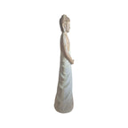 Back view of wood-look Buddhist statuette showing textured hair and long robe
