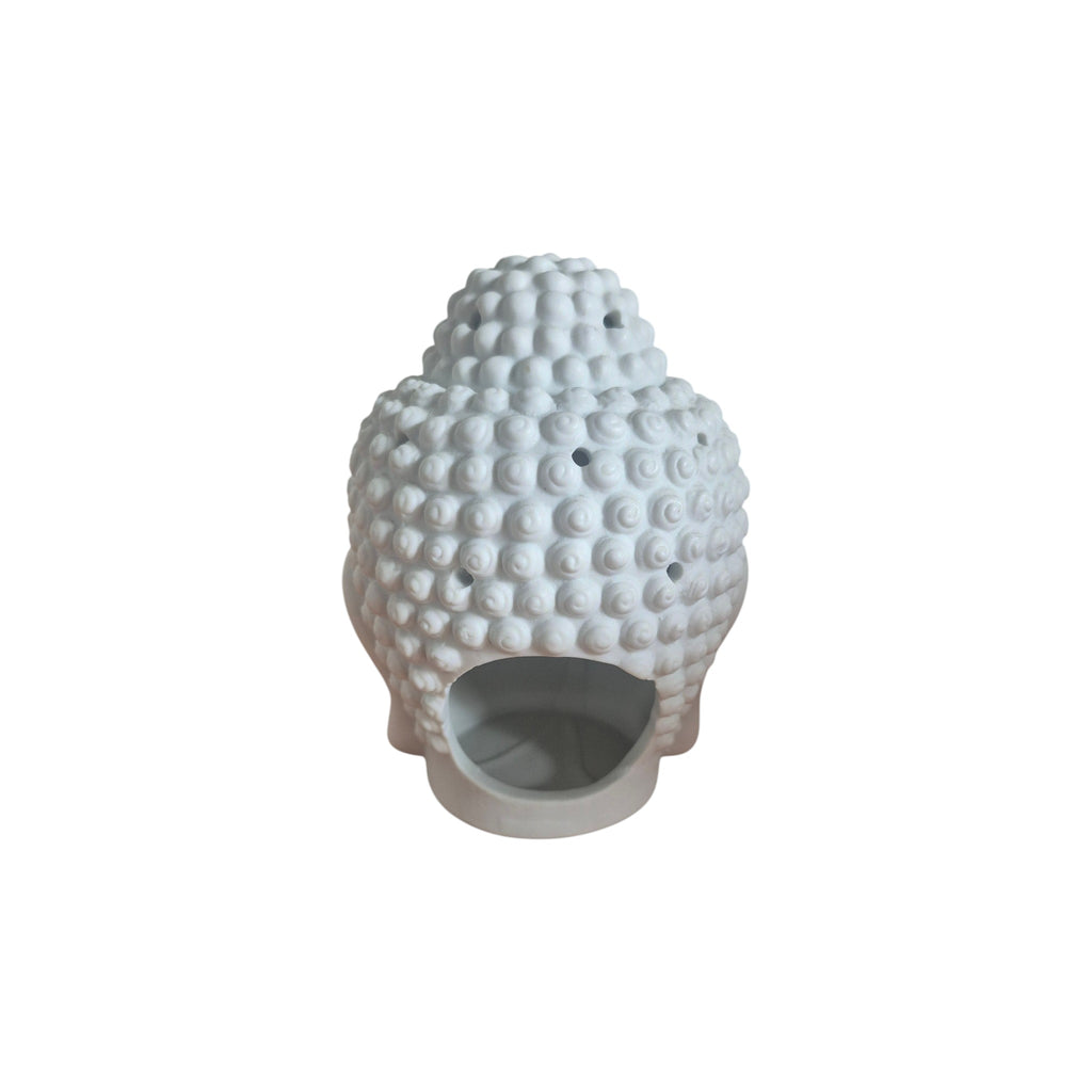 Top view of white Buddha head oil burner with removable cap beside open bowl