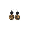 Pair of double disc PU leather earrings with small black textured discs above tan discs printed with black leafy branches and hook ear wires on white