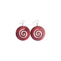 Pair of reddish-brown round wooden earrings with spiral cut-outs and gold-tone hook ear wires on a white background