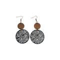 Double disc earrings with small brown discs above larger black circles with irregular cut-outs and bronze-tone hook ear wires on white