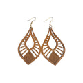 Pair of brown pointed wooden drop earrings with open centres, radiating geometric cut-outs, crosshatch-patterned bases and gold-tone hooks on white