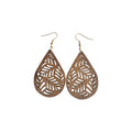 Pair of brown wooden teardrop earrings with leafy botanical cut-outs and gold-tone hook ear wires on a white background