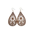 Pair of brown wooden teardrop earrings with large central flower cut-outs, symmetrical decorative openwork and gold-tone hook ear wires on white