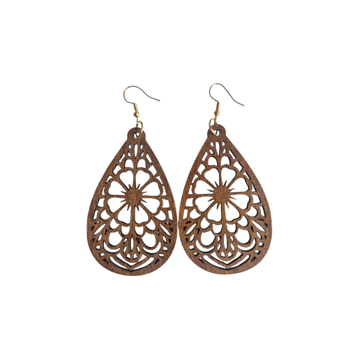 Pair of brown wooden teardrop earrings with large central flower cut-outs, symmetrical decorative openwork and gold-tone hook ear wires on white