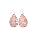 Pair of pink wooden teardrop earrings with symmetrical scroll-pattern cut-outs and silver-tone hook ear wires on a white background