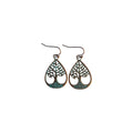 Pair of bronze-tone teardrop metal earrings with openwork tree of life designs, green root accents and hook ear wires on white